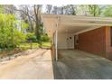 View of a single carport attached to a brick house with a small backyard at 244 Hurt Se Dr, Smyrna, GA 30082