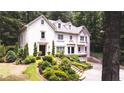 Charming two-story home with a well-manicured front yard and a variety of trees at 1165 E Beechwood Nw Dr, Atlanta, GA 30327