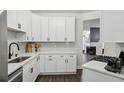 Modern kitchen with white cabinets, sleek countertops, stainless steel appliances, and backsplash at 63 Fulton Se St, Atlanta, GA 30312