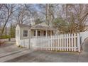 Well-kept home featuring a white picket fence and mature trees at 148 Murray Hill Ne Ave, Atlanta, GA 30317
