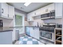 Well-lit kitchen featuring modern appliances, white cabinetry, and checkerboard flooring at 1901 Cumberland Ct, Smyrna, GA 30080