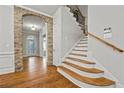 Foyer with hardwood floors, stone archway and staircase featuring wood and iron accents at 654 Crystal Cove Ct, Loganville, GA 30052