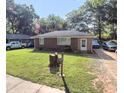 A quaint home with a green lawn, surrounded by mature trees, and some cars in the driveway at 212 Austin Ne Ave, Marietta, GA 30060