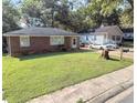 A single-story home with a grassy front yard, a brick facade, and an adjacent house at 212 Austin Ne Ave, Marietta, GA 30060