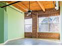 Spacious room with exposed brick walls, ceiling fan, and large windows allowing ample light at 204 Walker Sw St # 208, Atlanta, GA 30313