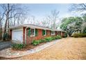 Brick ranch-style home with a detached garage, complemented by lush greenery and a stone walkway at 2191 Sweetwater Ln, Austell, GA 30106