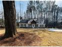 View of the home nestled on a spacious lot with mature trees and a circular driveway at 494 West Ave, Bowdon, GA 30108