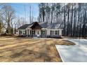 Charming home featuring a covered porch with timber accents and a concrete driveway at 494 West Ave, Bowdon, GA 30108