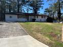 Charming single-story home with a well-manicured front yard and a concrete driveway at 4025 Gretna Green Dr, Decatur, GA 30035