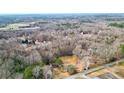 Expansive aerial view showcasing the red home, pond, and surrounding landscape at 257 Crossroads Church Rd, Rockmart, GA 30153