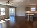 Open-concept living area showcasing dark wood floors, a kitchen island, and lots of natural light at 670 Pineberry Dr, Grayson, GA 30017