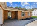 Brick home featuring a cozy covered entryway, gray shutters and landscaped mulched garden bed at 1604 Quail Sw Run, Conyers, GA 30094