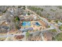 Aerial view highlighting community amenities, including a pool and tennis courts, surrounded by trees at 3775 Lake Seminole Dr, Buford, GA 30519