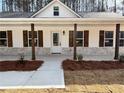 Close up of the front porch of a newly constructed home with stone accents and wood columns at 488 West Ave, Bowdon, GA 30108