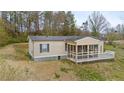 Tan manufactured home with a screened porch and a small deck on a grassy lawn at 718 Old Tennessee Ne Hwy, White, GA 30184