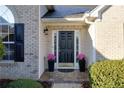 Elegant front door with sidelights and transom window, complemented by potted plants and brick facade at 4030 Crescent Walk Ne Ln, Suwanee, GA 30024