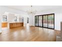 Open-concept living space with hardwood floors, modern light fixture, and expansive glass doors to the backyard at 555 Orme Ne Cir, Atlanta, GA 30306
