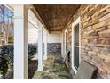 Inviting covered front porch featuring stone accents, tile flooring, and outdoor seating at 2941 Foothill Trl, Marietta, GA 30066