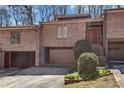 Inviting brick townhouse with a private garage and front entrance, complemented by well-maintained landscaping at 5545 Circlestone Ln, Stone Mountain, GA 30083