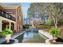 Backyard swimming pool and waterfall feature surrounded by lush greenery for a private oasis at 5400 Saint Lyonn Pl, Marietta, GA 30068
