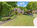 Beautiful two-story brick home with mature trees, landscaping and inviting curb appeal at 2802 Nettle Ln, Buford, GA 30519