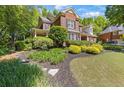 Traditional brick home featuring manicured lawn, mature trees, and tidy landscaping at 2802 Nettle Ln, Buford, GA 30519