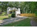 Spacious two-story home with an attached garage, nestled among mature trees and featuring a fenced backyard at 3003 Maple Ln, Alpharetta, GA 30009