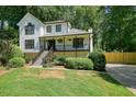 Attractive two-story home with a covered front porch, complemented by lush greenery and a well-maintained lawn at 3003 Maple Ln, Alpharetta, GA 30009