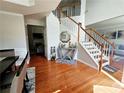 Inviting foyer features hardwood floors, a staircase with white banisters, and a view into the living area, creating a warm welcome at 2283 Shady Maple Ln, Loganville, GA 30052