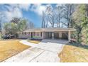 Quaint single-story home with an attached carport and an expansive driveway at 4281 Welbron Dr, Decatur, GA 30035