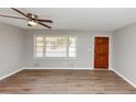 Bright living room featuring laminate wood flooring, a ceiling fan, and a large window at 4281 Welbron Dr, Decatur, GA 30035