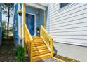 Inviting front porch with wooden stairs, railing, and a pop of color on the front door at 813 Smith Sw St # B, Atlanta, GA 30310