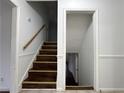 Staircase with hardwood steps and white trim leading to the basement, freshly painted with newel post at 2717 Rosemont Dr, Lawrenceville, GA 30044