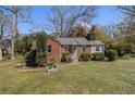 Inviting brick home with lush green lawn, mature trees, and quaint front porch at 3542 W Hill St, Clarkston, GA 30021