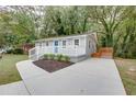 A single-story home featuring a blue front door, updated siding, concrete driveway and manicured front yard at 2598 Elliott Nw St, Atlanta, GA 30318