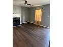 A gray-walled living room with wood flooring, a ceiling fan, and a fireplace at 6682 Biscayne Blvd, Rex, GA 30273
