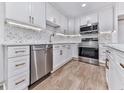 Bright kitchen features modern stainless appliances, white cabinets, and stylish hexagon backsplash at 221 Wonewok Dr, Canton, GA 30114