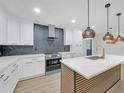 Modern kitchen featuring a large island with stylish pendant lighting at 137 Creekview Dr, Woodstock, GA 30188