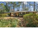 Exterior of a charming brick home with a walkway surrounded by greenery and mature trees at , Atlanta, GA 30329