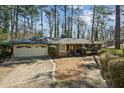 Exterior of a red brick ranch home with 2-car garage and mature trees at , Atlanta, GA 30329