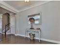 Inviting entryway with dark hardwood floors, decorative table with mirror, and views of the staircase at 301 Cochin Dr, Woodstock, GA 30188