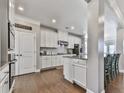 Modern kitchen with white cabinets, stainless steel appliances, granite countertops, and hardwood flooring at 301 Cochin Dr, Woodstock, GA 30188