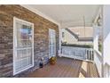 Inviting front porch featuring a cozy swing, stone accent wall, and natural light, creating a relaxing outdoor space at 106 Birchwood Pass, Canton, GA 30114