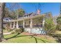 A charming home featuring a cozy front porch, lush green lawn, and established trees at 1118 Glenwood Se Ave, Atlanta, GA 30316