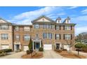 Inviting brick townhome with an attached garage, blue shutters, and manicured landscaping at 1868 Appaloosa Mill Ct, Buford, GA 30519