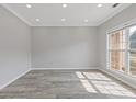 A bright room with hardwood floors, white trim, crown molding, and a large window at 1516 Montauk Pt, Conyers, GA 30013