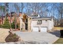 Brick two-story home featuring a stone entrance, two-car garage, and expansive driveway at 3290 Coachmans Way Ne Way, Roswell, GA 30075