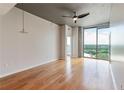 Bright bedroom with hardwood floors, bare concrete pillars and ceiling, and sliding glass windows offering city views at 361 17Th St # 1516, Atlanta, GA 30363