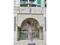 Modern building entrance showcasing an arch design, glass doors, and concrete walls, complemented by a young tree at 361 17Th St # 1516, Atlanta, GA 30363