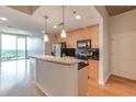 Stylish kitchen featuring wooden cabinets, a black backsplash, and stainless appliances, situated next to a bright living area at 361 17Th St # 1516, Atlanta, GA 30363